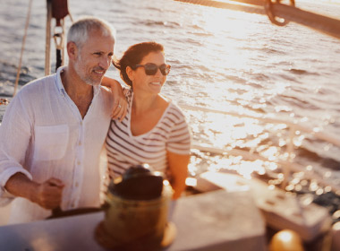 Mature couple look onward while they boat